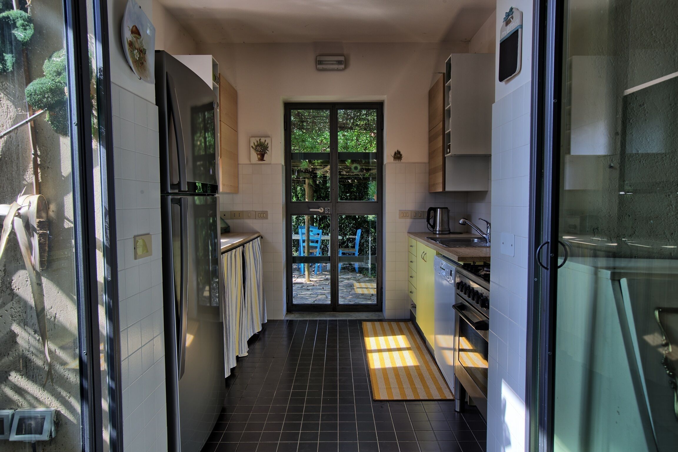 A narrow kitchen with a sliding glass door leading to a patio.
