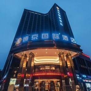 A hotel with a prominent sign in Chinese characters, a classical architectural style with columns, and a modern lighting design. - Bo Jing International Hotel (Hangzhou)