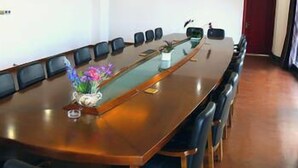 A conference room with a long table, chairs, and a potted plant. - Bo Jing International Hotel (Hangzhou)