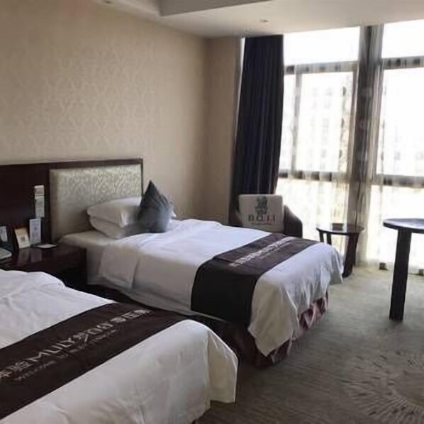 A hotel room with two beds, a nightstand, a chair, and a small table. - Bo Jing International Hotel (Hangzhou)