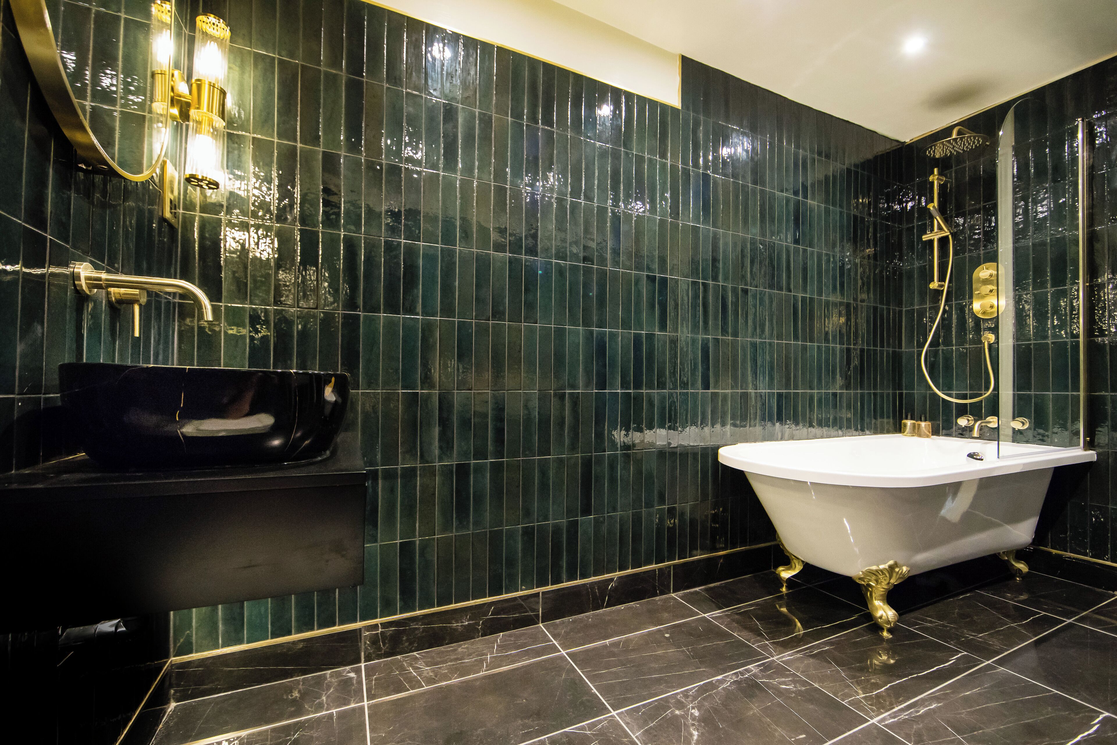 A modern bathroom with a freestanding bathtub, a vanity with a black sink, and a shower area with a glass-enclosed tub.
