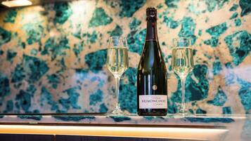 Una botella de champán Brimontcourt y dos copas sobre una encimera con salpicadero de mármol.