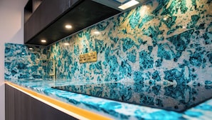 A marble countertop with a sink, a gold faucet, and a sign with dice symbols.