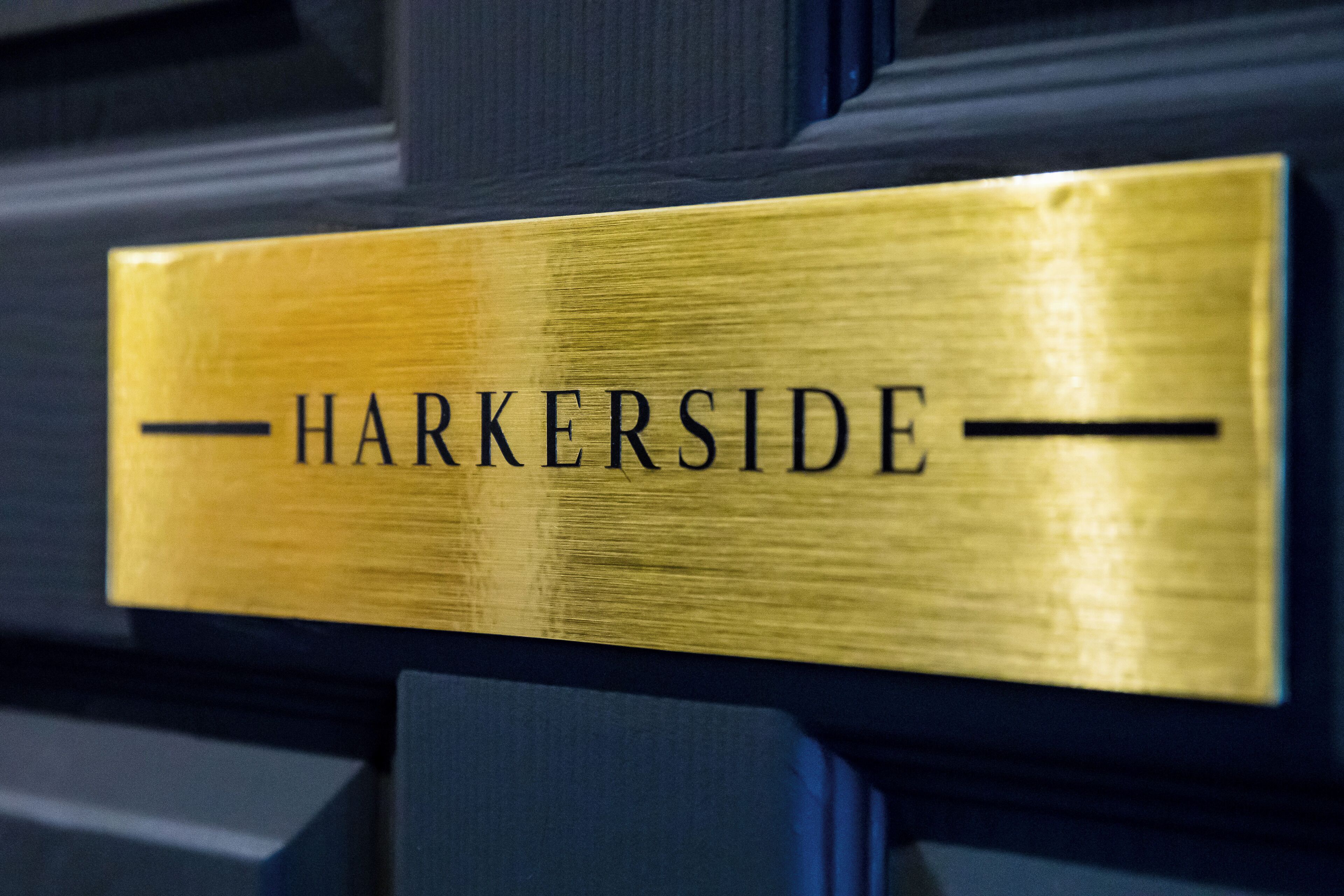 A brass nameplate with the inscription "HARKERSIDE" on a dark, textured background.