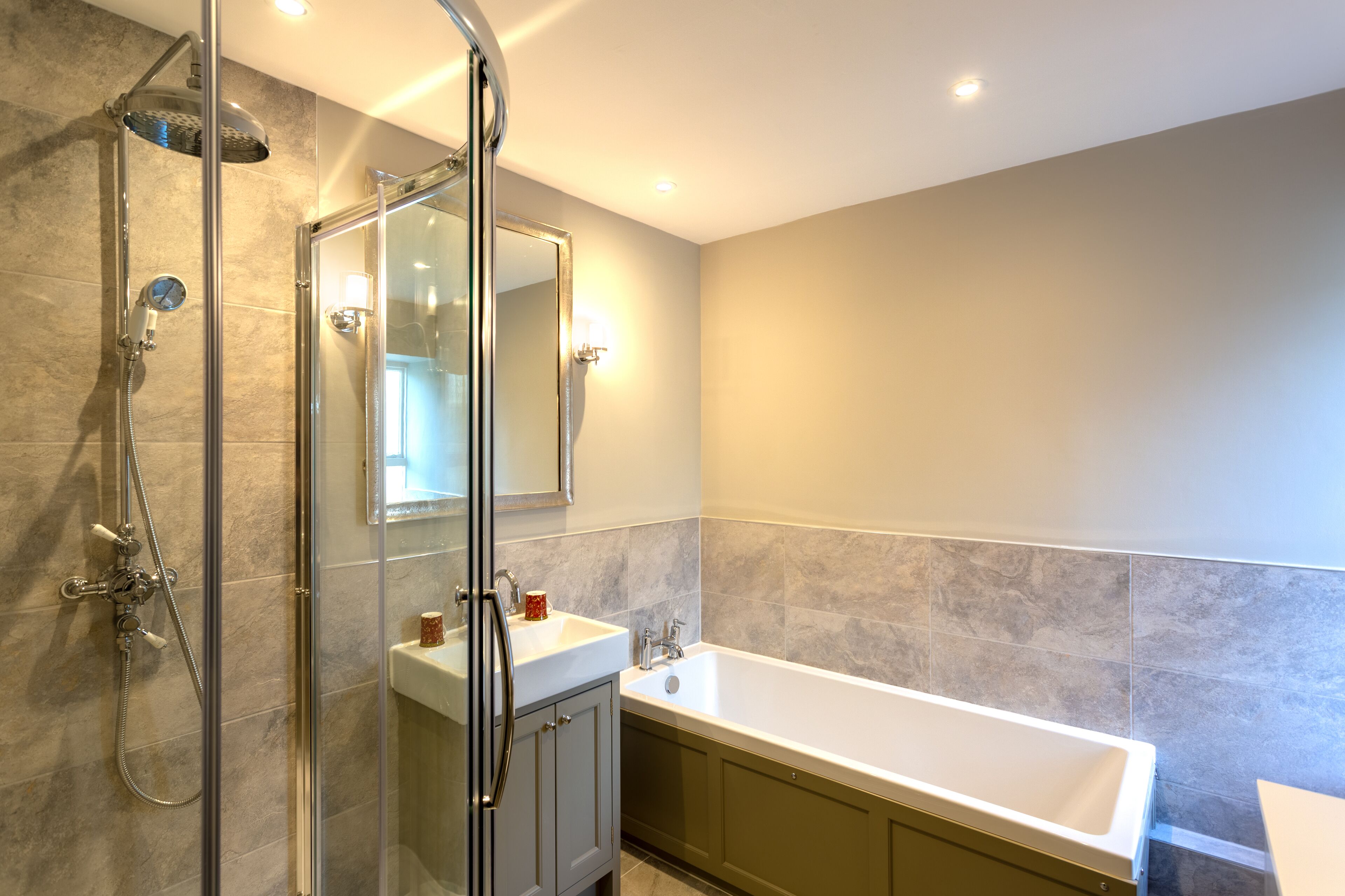 Une salle de bain moderne dotée d’une douche à parois de verre, d’une baignoire sur pieds et d’un meuble-lavabo avec un miroir.