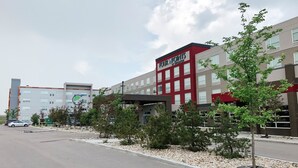 A multi-story hotel with a red and grey facade, named 'Four Points by Sheraton'.