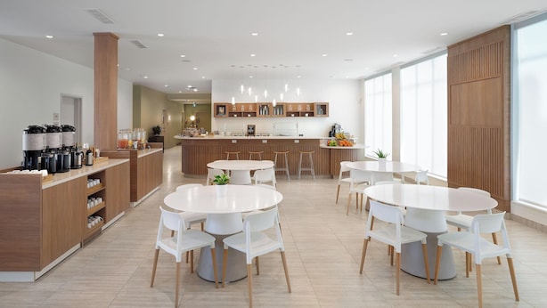 A modern kitchen with a central island, bar area, and seating for six.