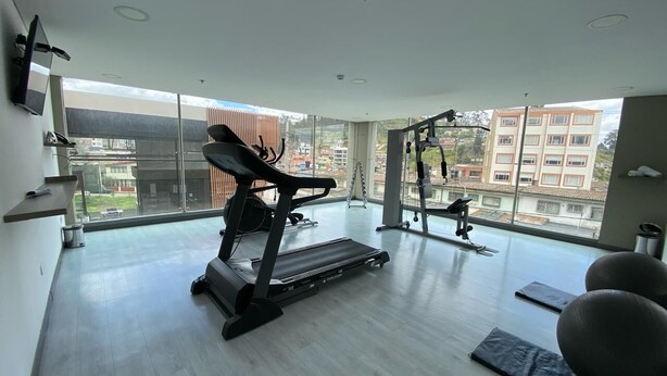 Un gimnasio moderno con cinta de correr, pelotas de ejercicio y barra para dominadas.