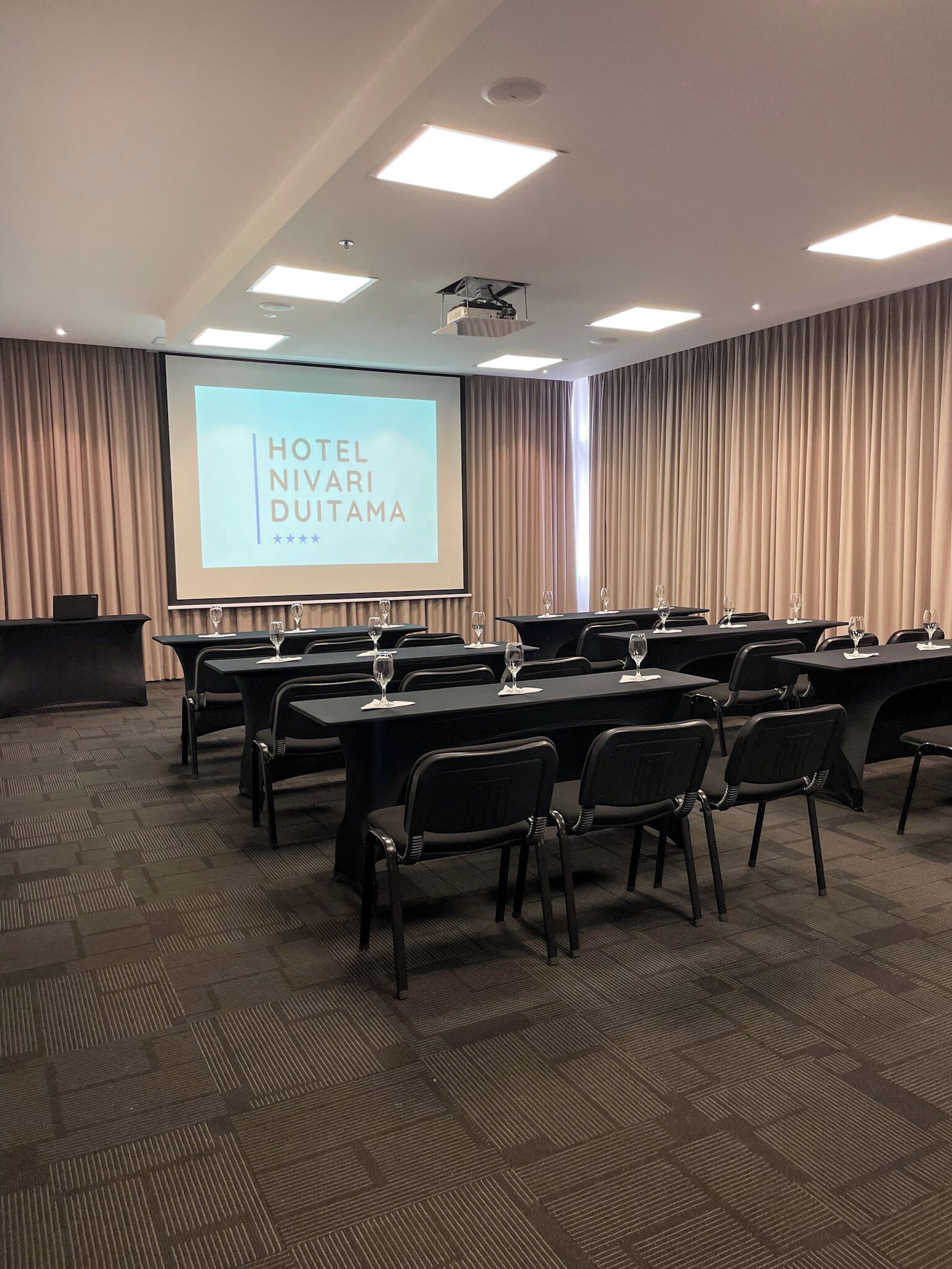 Un salón de conferencias con una pantalla grande mostrando 