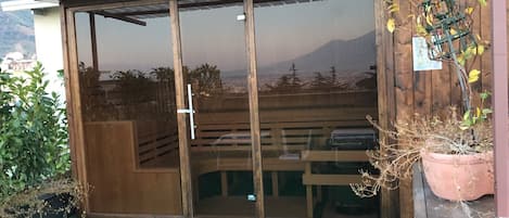 A sliding glass door leading to a covered outdoor area with a view of a mountain range.