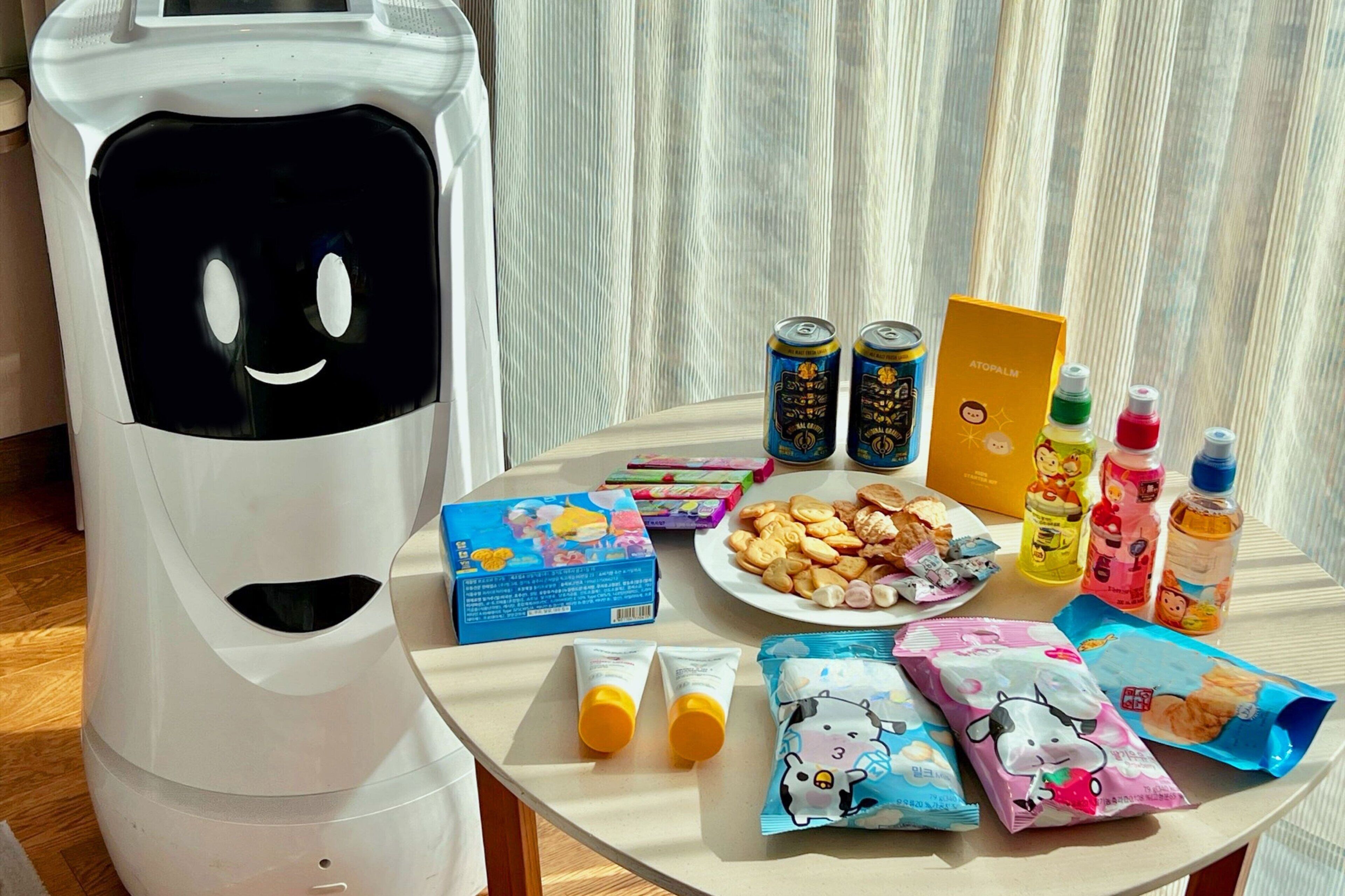 A table with snacks, drinks, and a toy robot.