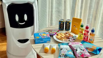 A table with snacks, drinks, and a toy robot.