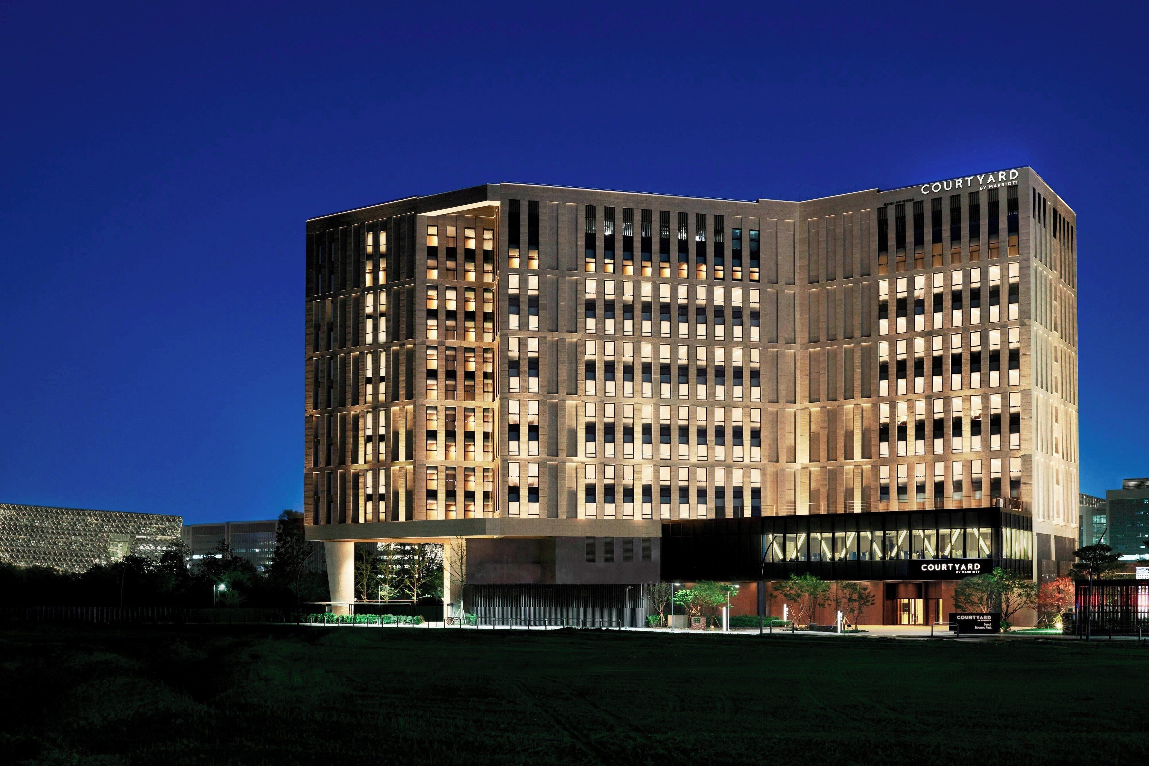 A modern hotel with a prominent 'Courtyard' sign, featuring a grid-like facade and multiple windows.