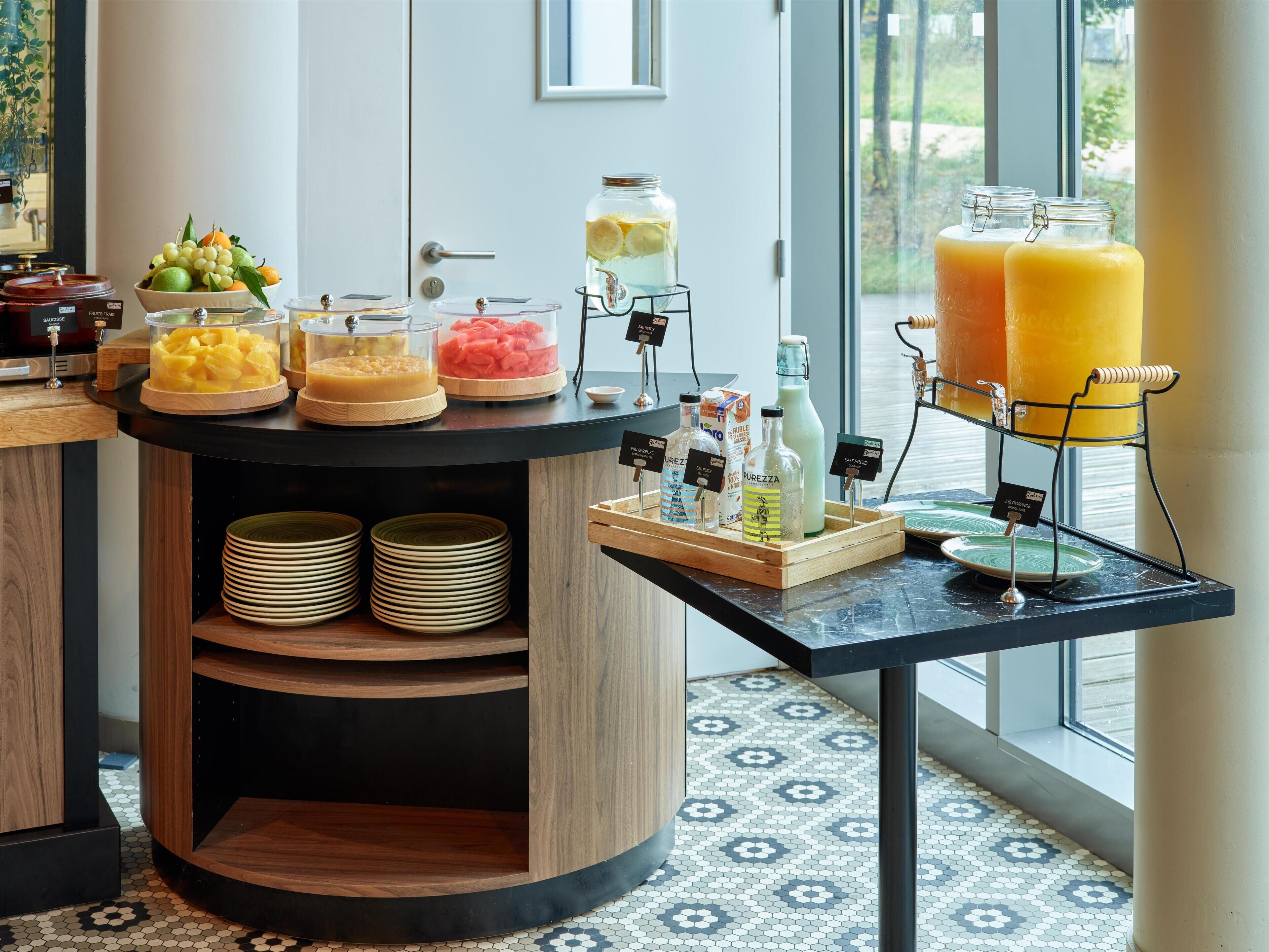Um buffet de café da manhã com diversos alimentos e bebidas.