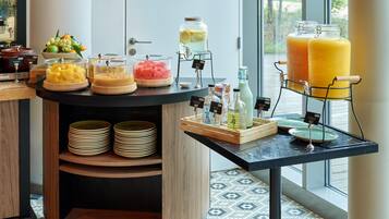 Um buffet de café da manhã com diversos alimentos e bebidas.