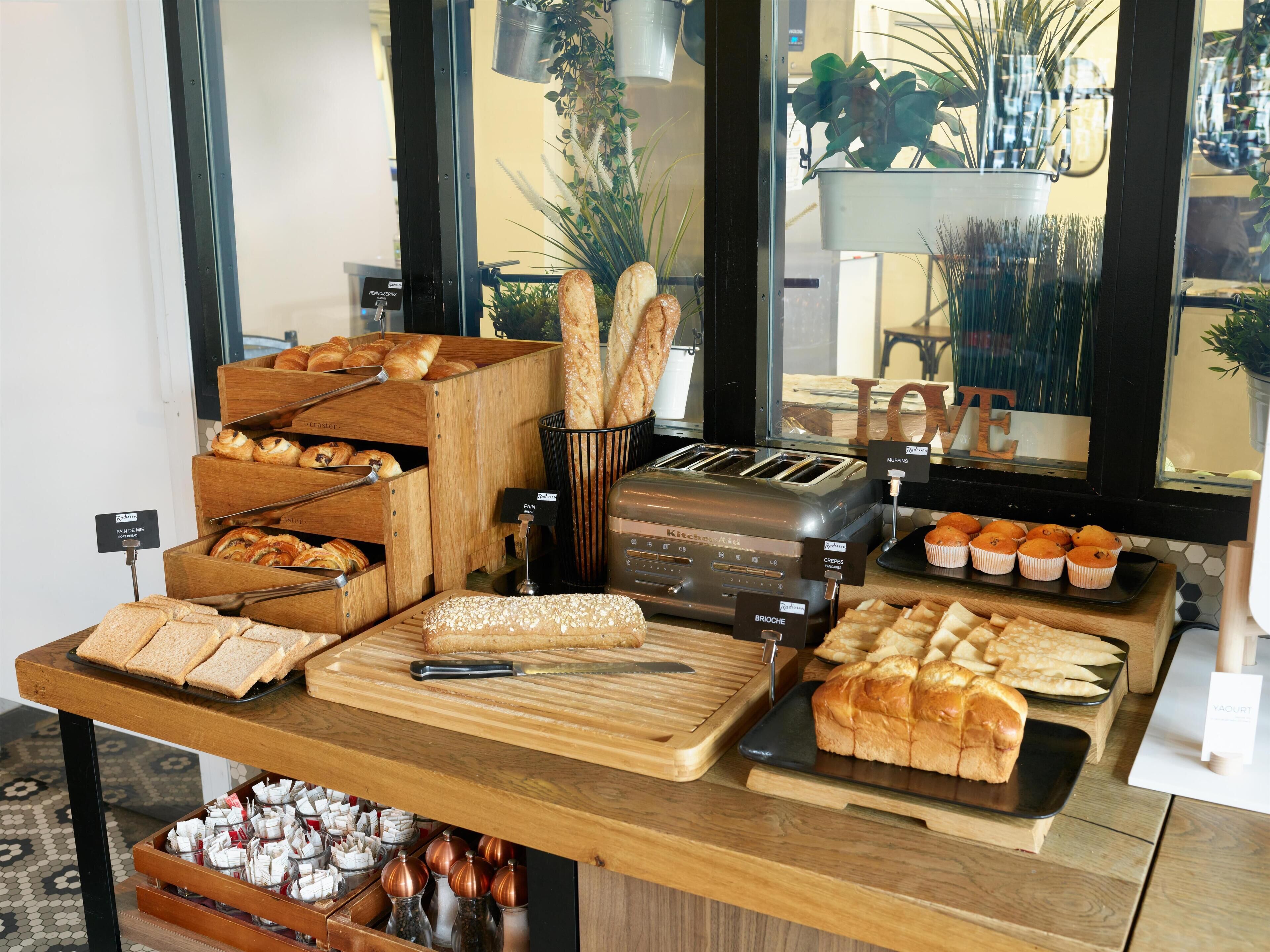 A bakery display with various breads, pastries, and a toaster.
