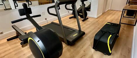 A gym with treadmills, a stationary bike, and a rowing machine.