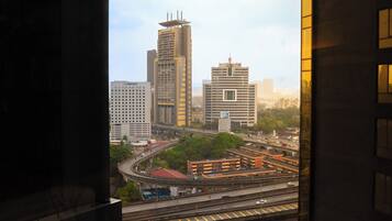 A cityscape with high-rise buildings, a highway, and a parking structure.