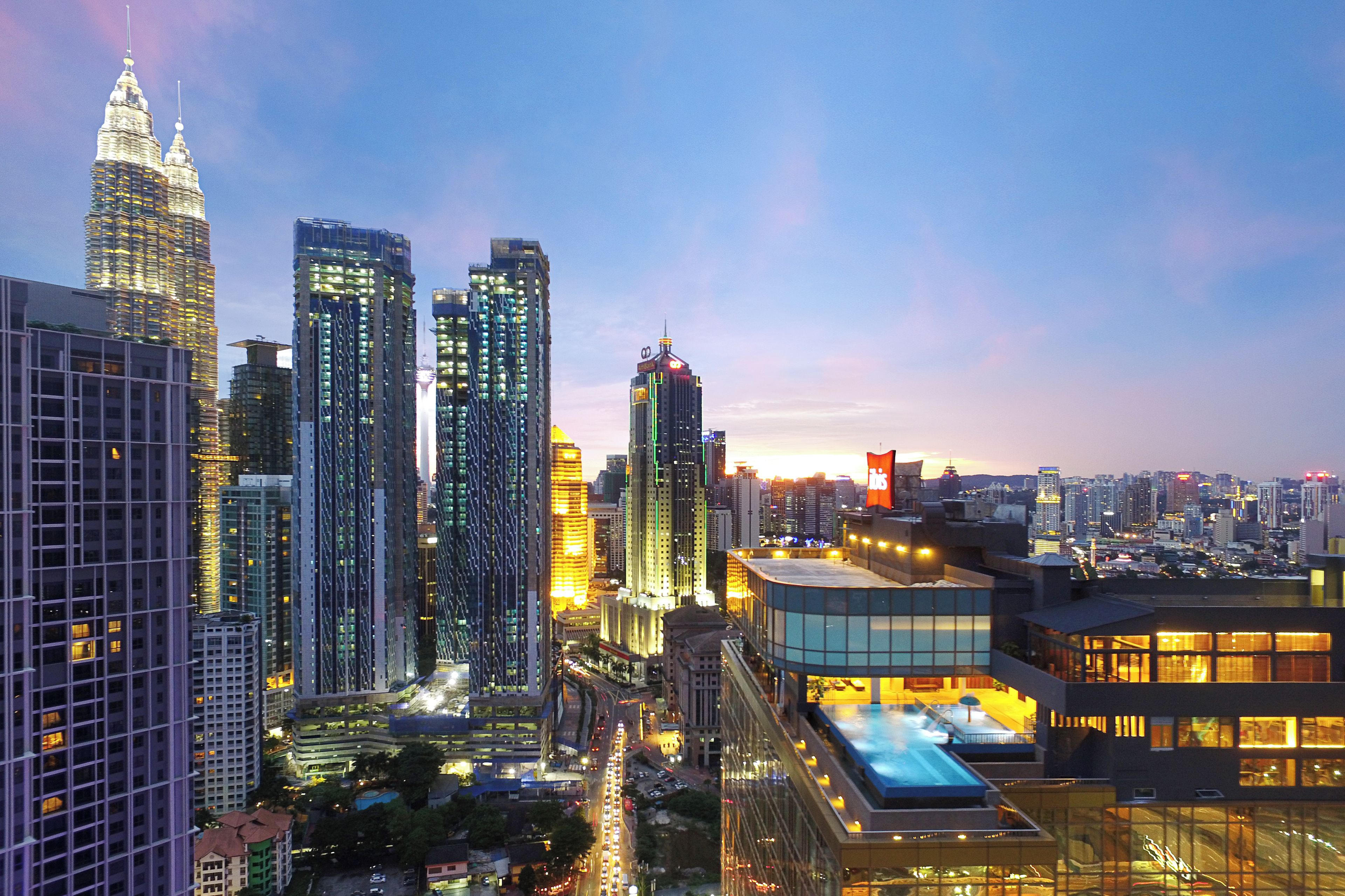A cityscape with high-rise buildings, including a prominent skyscraper with a unique design.