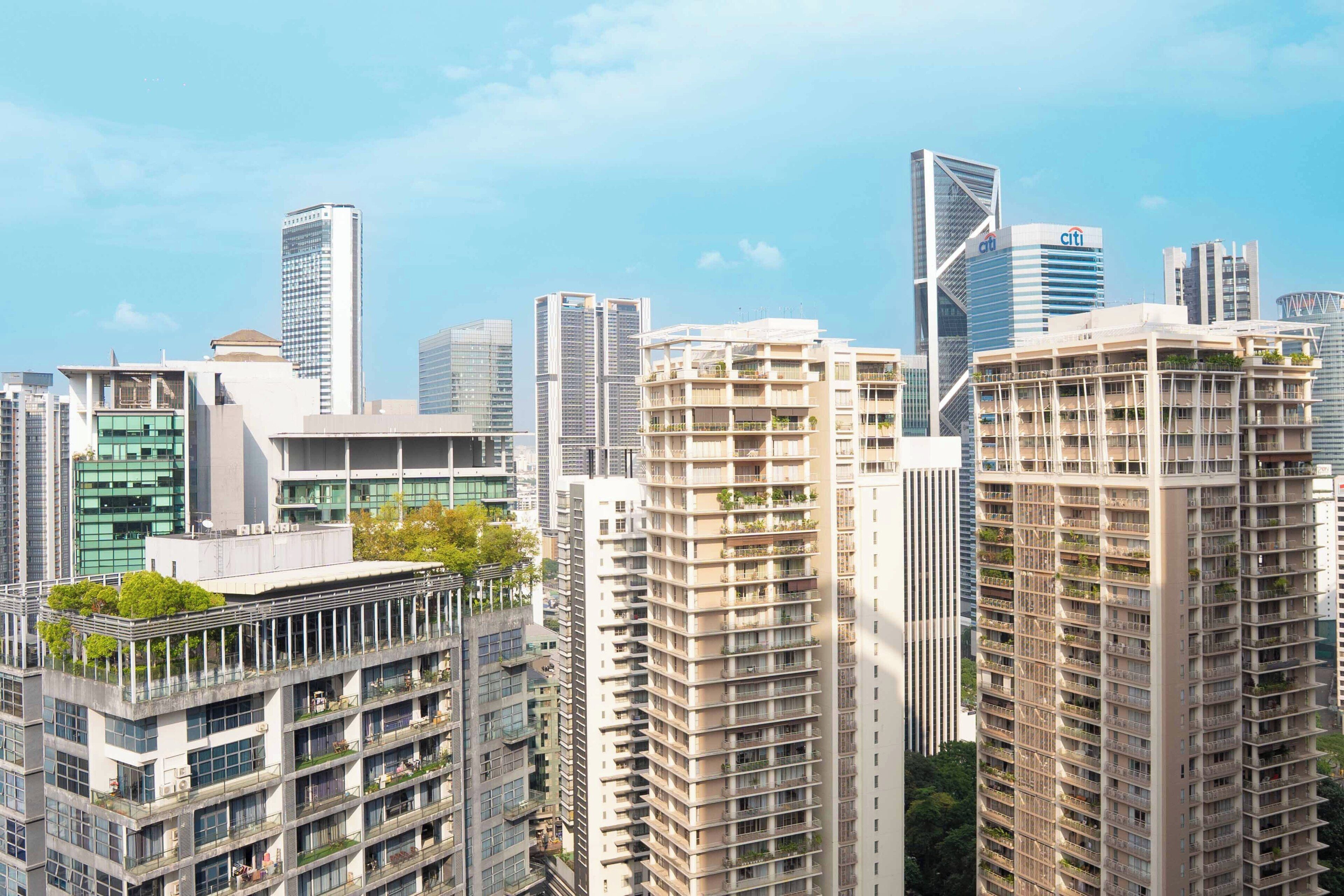 A cityscape with high-rise buildings, including a prominent building with a distinctive triangular top.