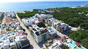 A coastal residential area with modern buildings, a beach, and a pier. - IT Boutique Hotel & Restaurant (Playa del Carmen)