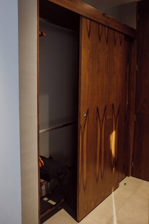 A wooden wardrobe with a sliding door, a metal handle, and a visible shelf inside. - IT Boutique Hotel & Restaurant (Playa del Carmen)