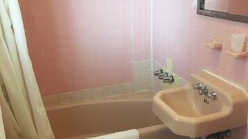 A bathroom with a bathtub, sink, and toilet.