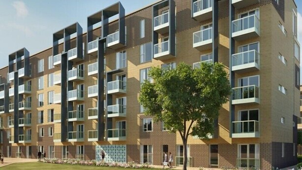 A multi-story residential building with balconies, large windows, and a tree in front. - Signet Apartments-Vesta (Cambridge)