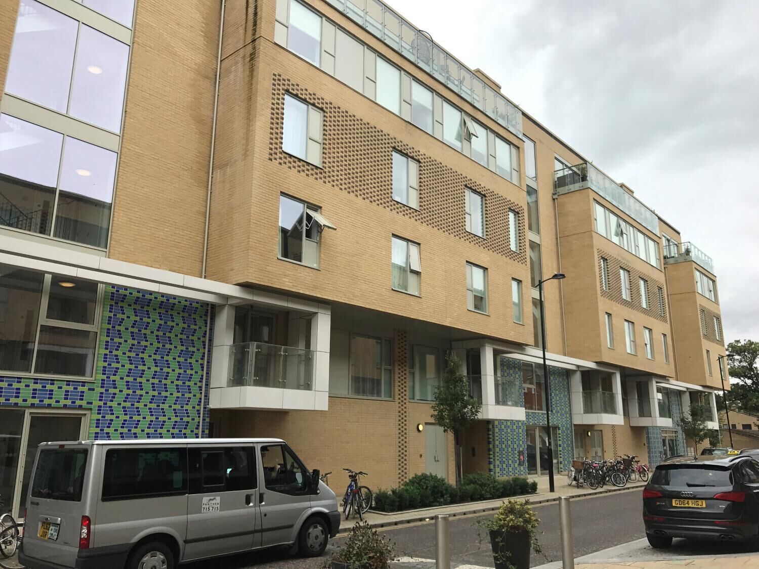 Un edificio residencial de varios pisos con un diseño moderno, que cuenta con amplios ventanales y balcones.