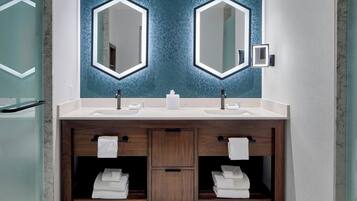 Une salle de bain moderne avec deux vasques, des meubles en bois et un mur bleu à texture.