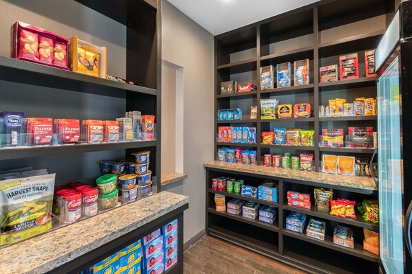 Una despensa bien organizada con estantes llenos de aperitivos, cereales y alimentos enlatados.
