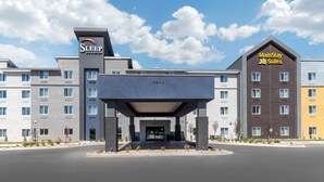 A hotel with a modern design, featuring a prominent entrance and multiple buildings with different color facades. - Sleep Inn & Suites Denver International Airport (Denver)