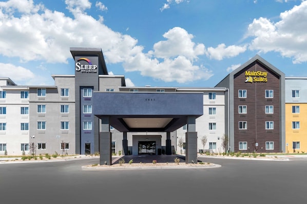 A hotel with a modern design, featuring a prominent entrance and multiple buildings with different color facades.
