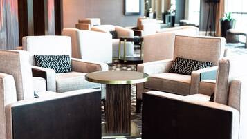 A modern hotel lobby with seating arrangements and a central round table.