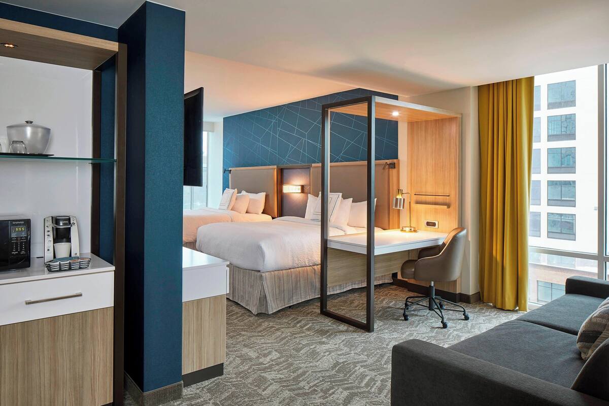 Une chambre d’hôtel comprenant un lit, un bureau et un coin salon.