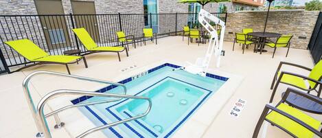 Área de piscina com trampolim, espreguiçadeiras e mesas com guarda-sóis.
