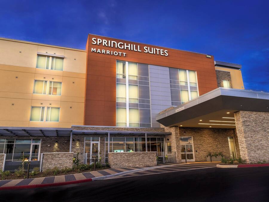 A modern hotel with a large sign reading "Springhill Suites Marriott" and a covered entrance area.