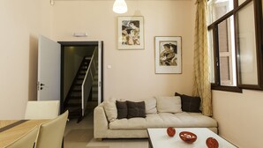 A living room with a sofa, a dining table, and two framed artworks on the wall. - City center house in Rhodes (Rhodes)