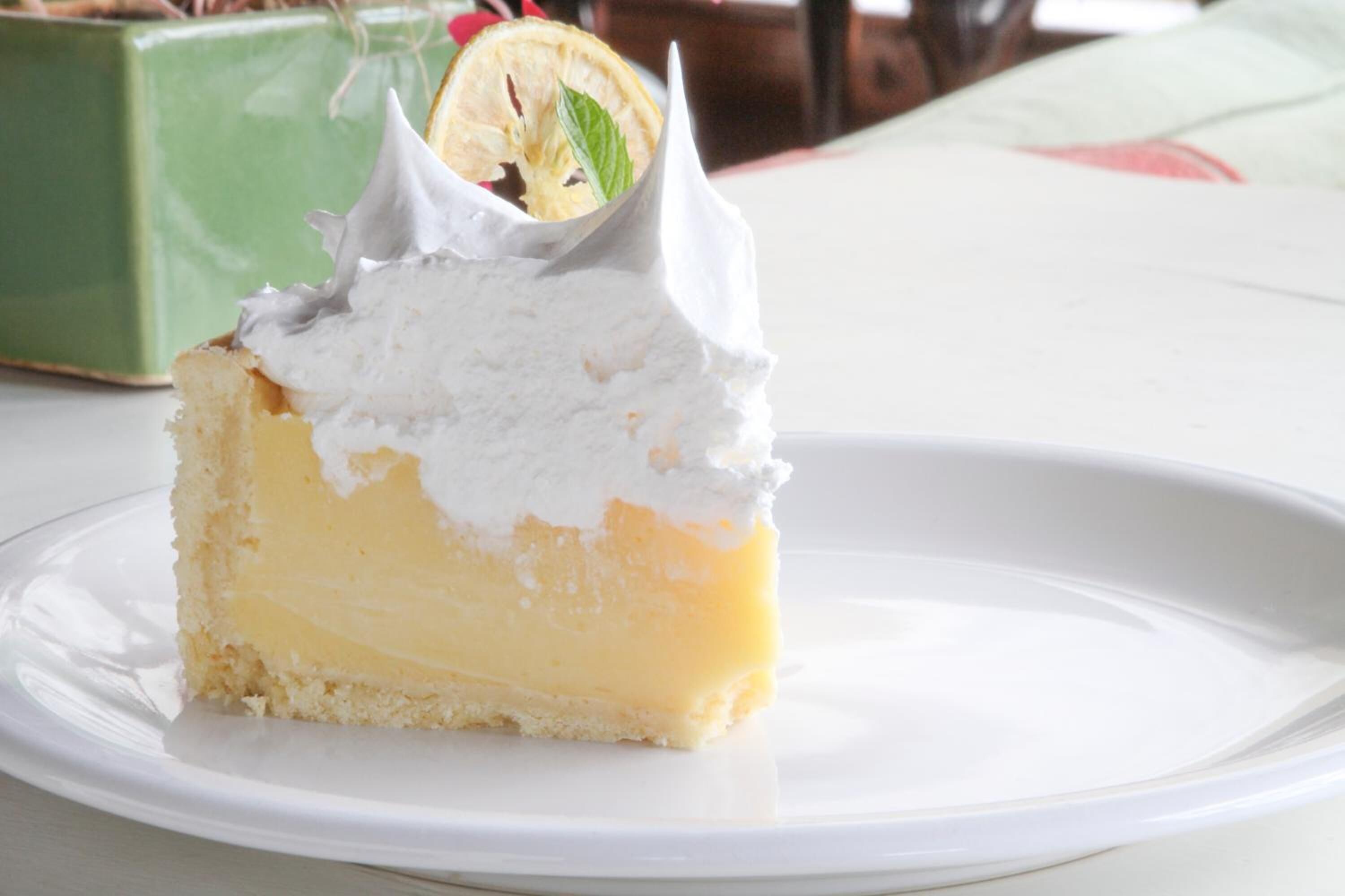 A slice of lemon tart on a white plate.