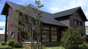 A two-story building with a sloped roof and large windows. - Kaulem Hotel Boutique (El Chalten)