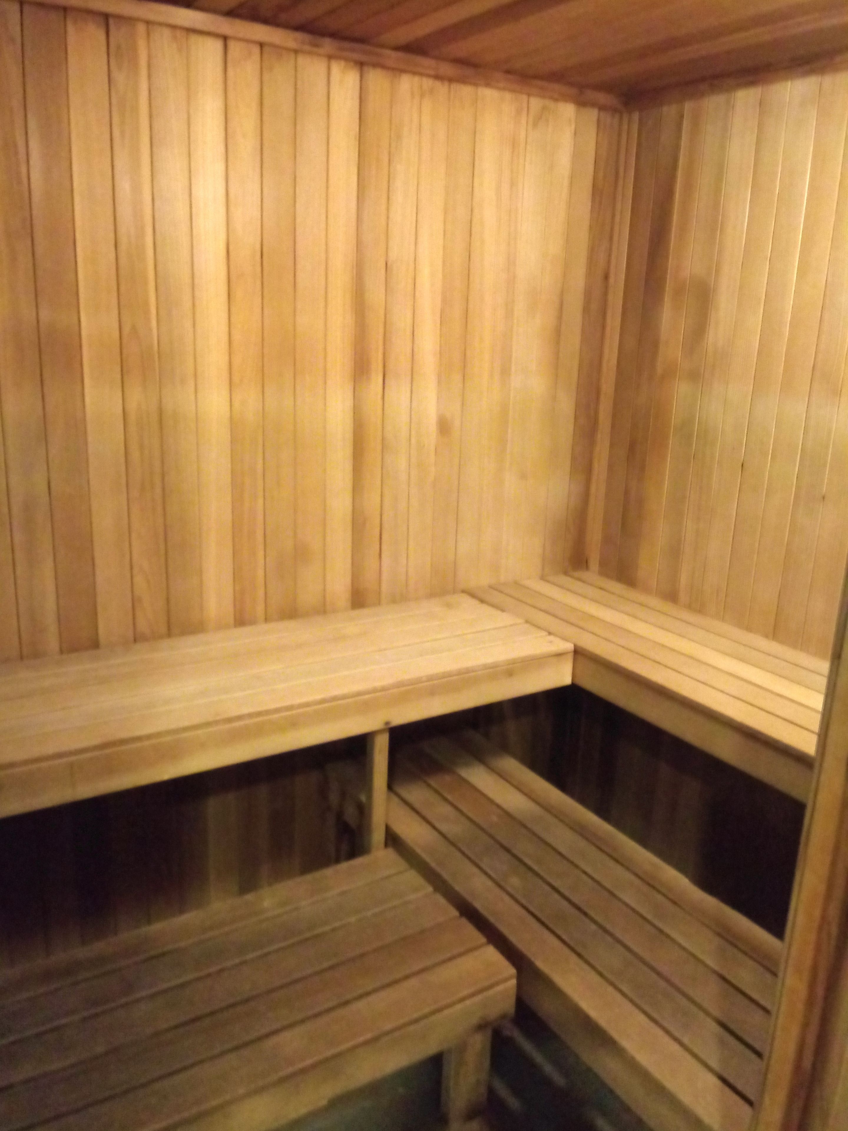 En sauna med træbænke og skråt gulv.