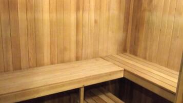 A sauna with wooden benches and a sloped floor design.