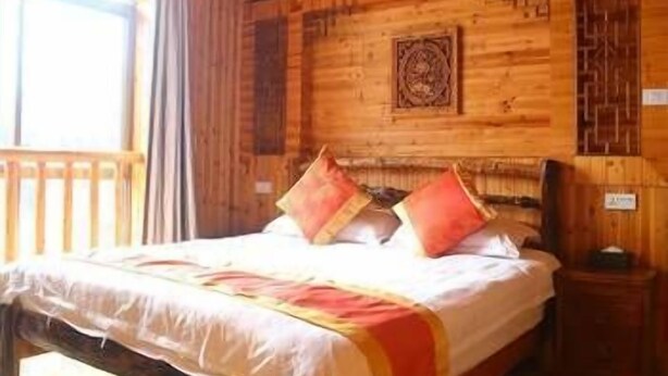 A wooden cabin bedroom with a bed, pillows, a nightstand, and a window. - Li Ru Yododo Villa (Guilin)