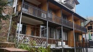 A multi-story building with a balcony on the ground floor, wooden beams, and a stone facade. - Li Ru Yododo Villa (Guilin)