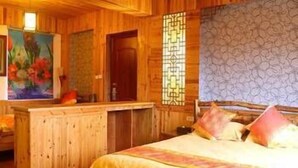 A wooden cabin-style room with a bed, a painting, and a decorative screen. - Li Ru Yododo Villa (Guilin)