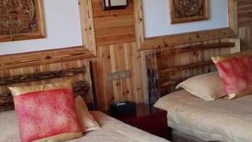 Una habitación de hotel con dos camas, cabeceros de madera y obras de arte enmarcadas en las paredes.
