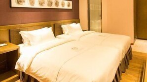 Camera d'albergo con un letto grande, una testiera in legno e un'opera d'arte appesa al muro.