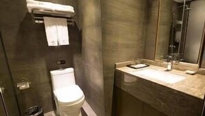 Un bagno moderno con toilette, lavandino e specchio.