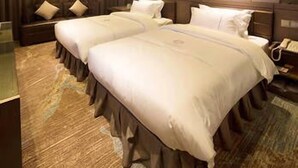Una camera d'albergo con due letti, uno specchio grande e un design moderno.