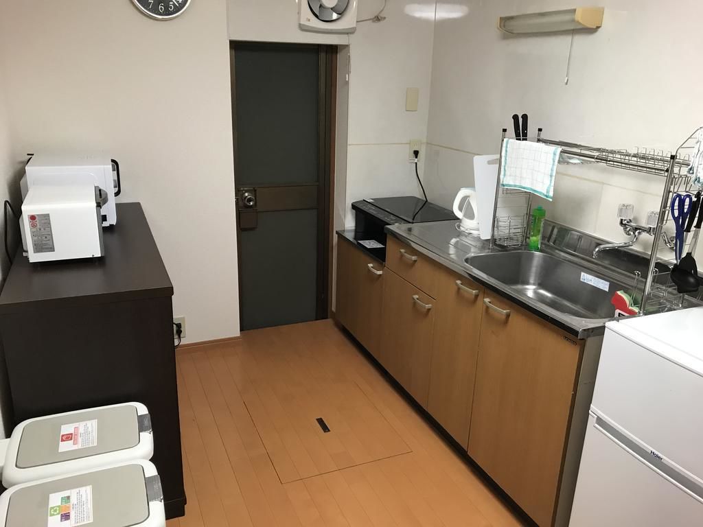 A compact kitchen with a microwave, coffee maker, and sink.